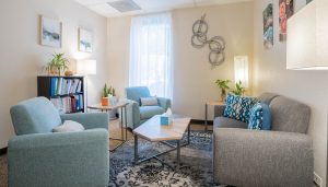 Front Range Psychological Services office number 2 in Arvada, CO with a sofa, 2 chairs, and light colored decor.